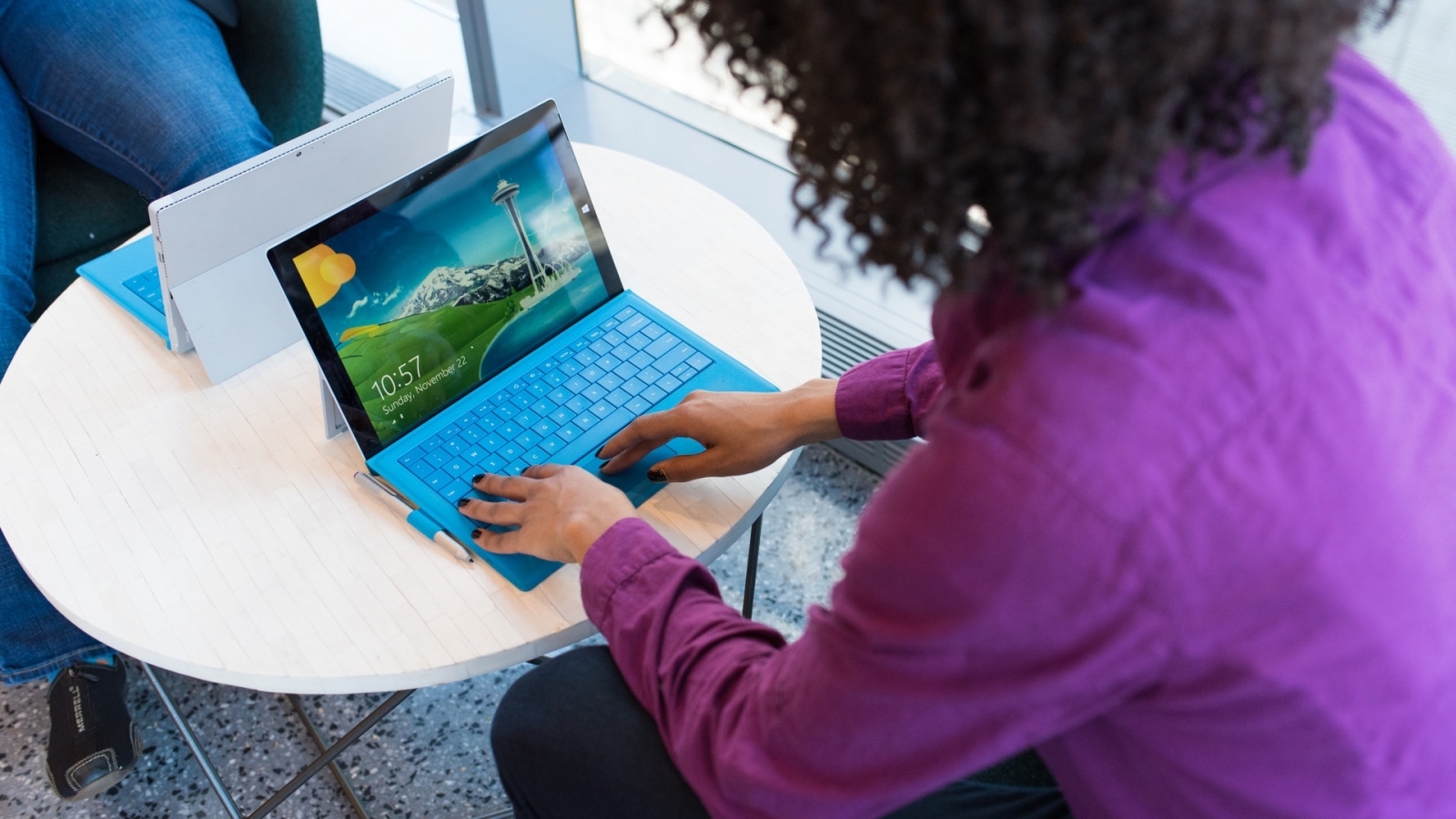 person-using-blue-laptop-sitting-beside-table-1181240