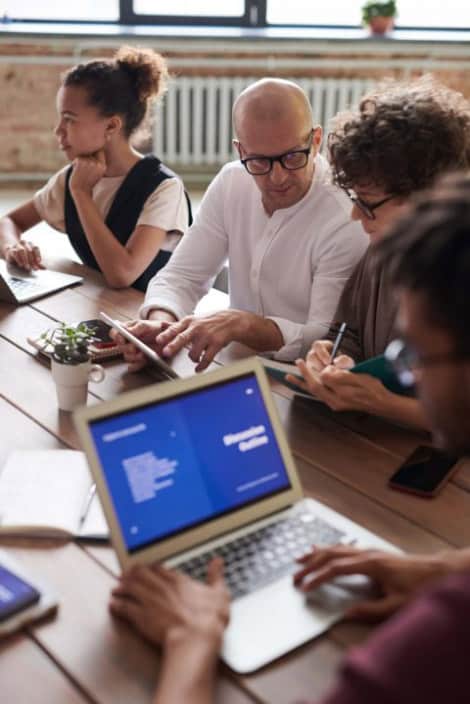 photo-of-people-working-near-brown-wooden-table
